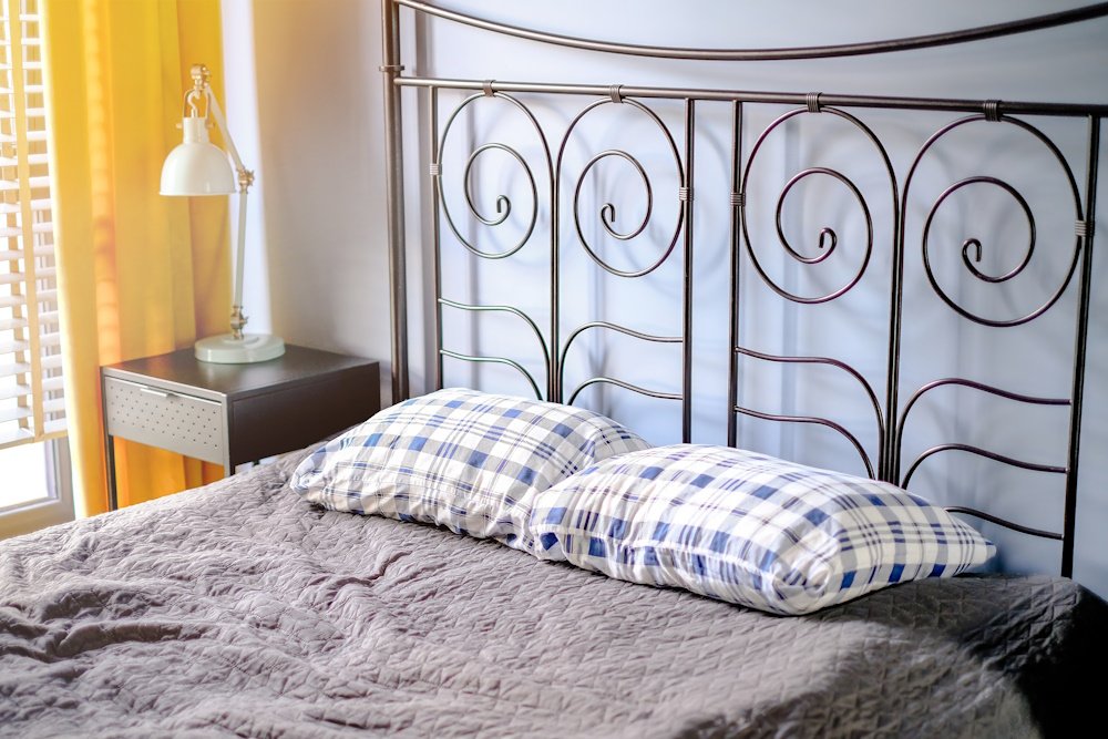 a mattress and pillows on top of a metal bed frame