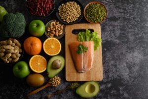 legumes, fruit, and Salmon fish pieces on a wooden chopping boar