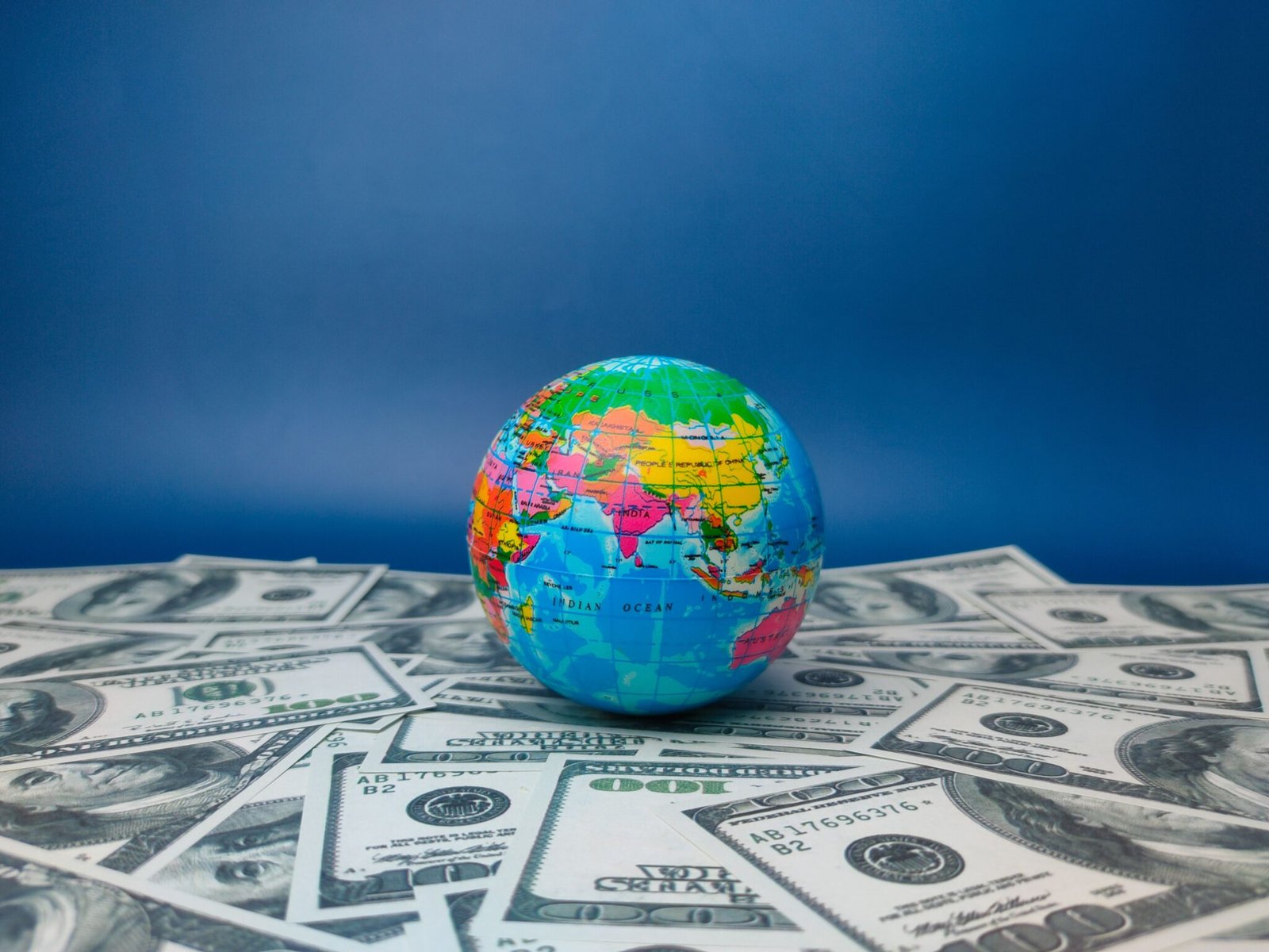 A globe resting on a stack of banknotes