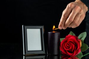 front-view-dark-candle-with-red-rose-picture-frame-dark-surface