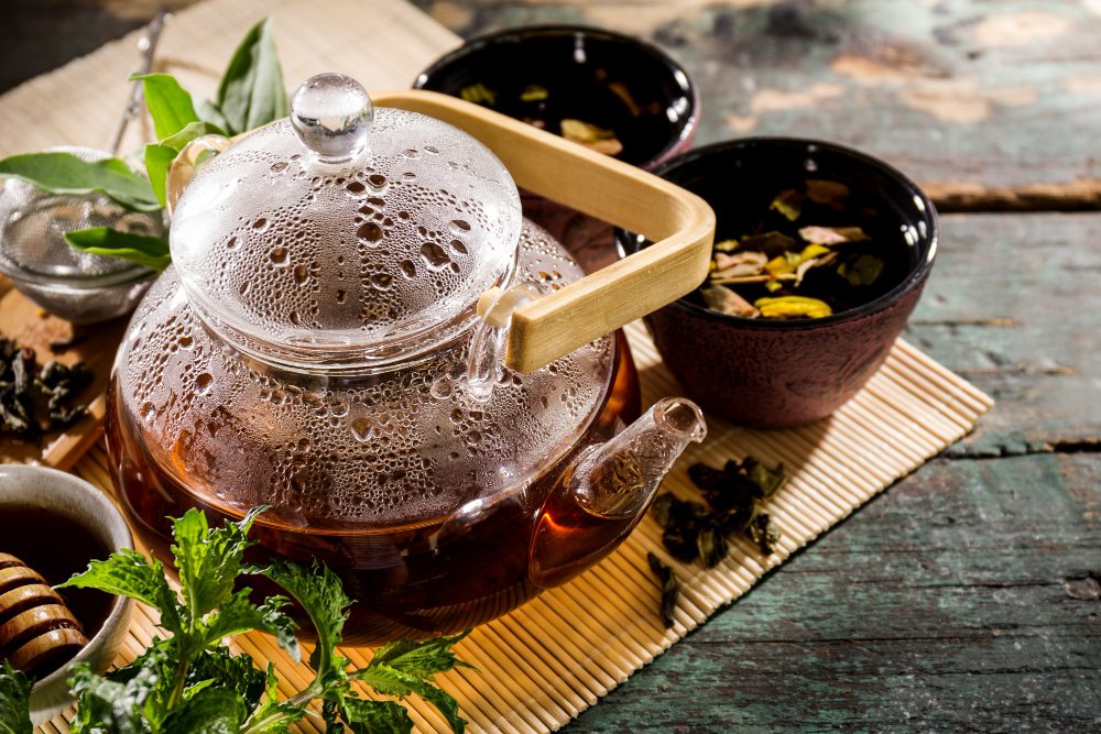 Teapot with tea and herbs.