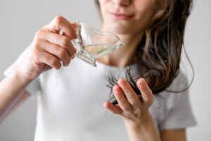 Woman applying serum on hair