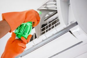 Man wearing gloves cleaning aircon